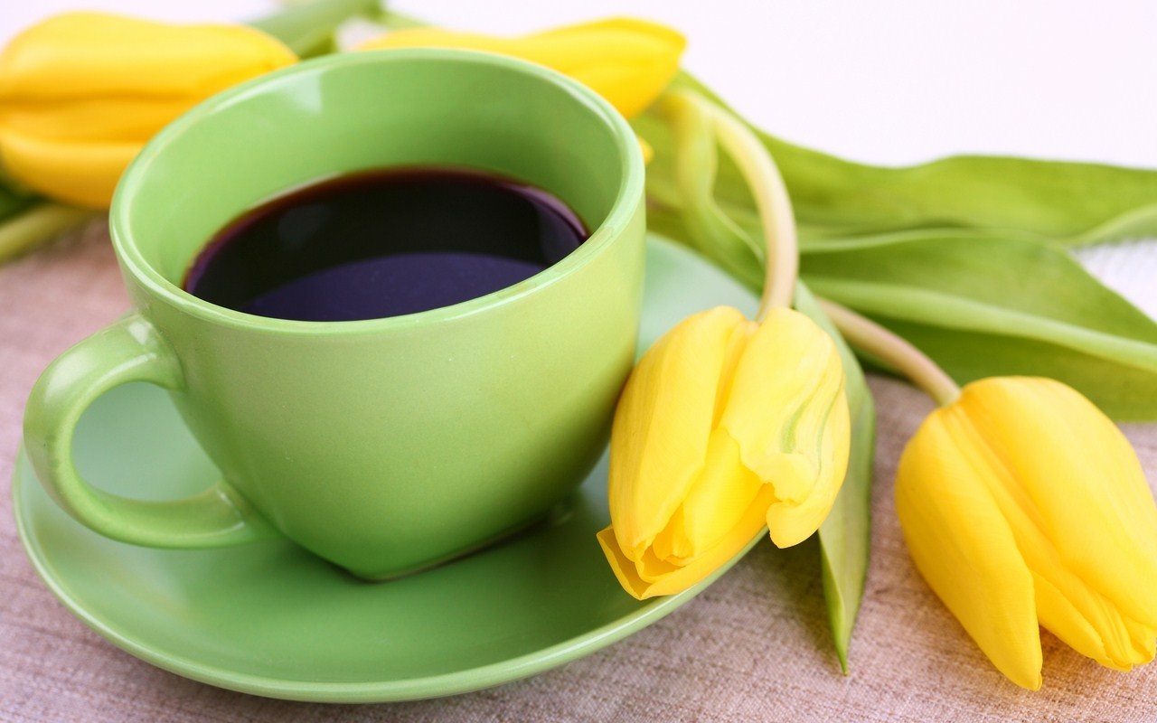 Coffee in green cup and daffodils